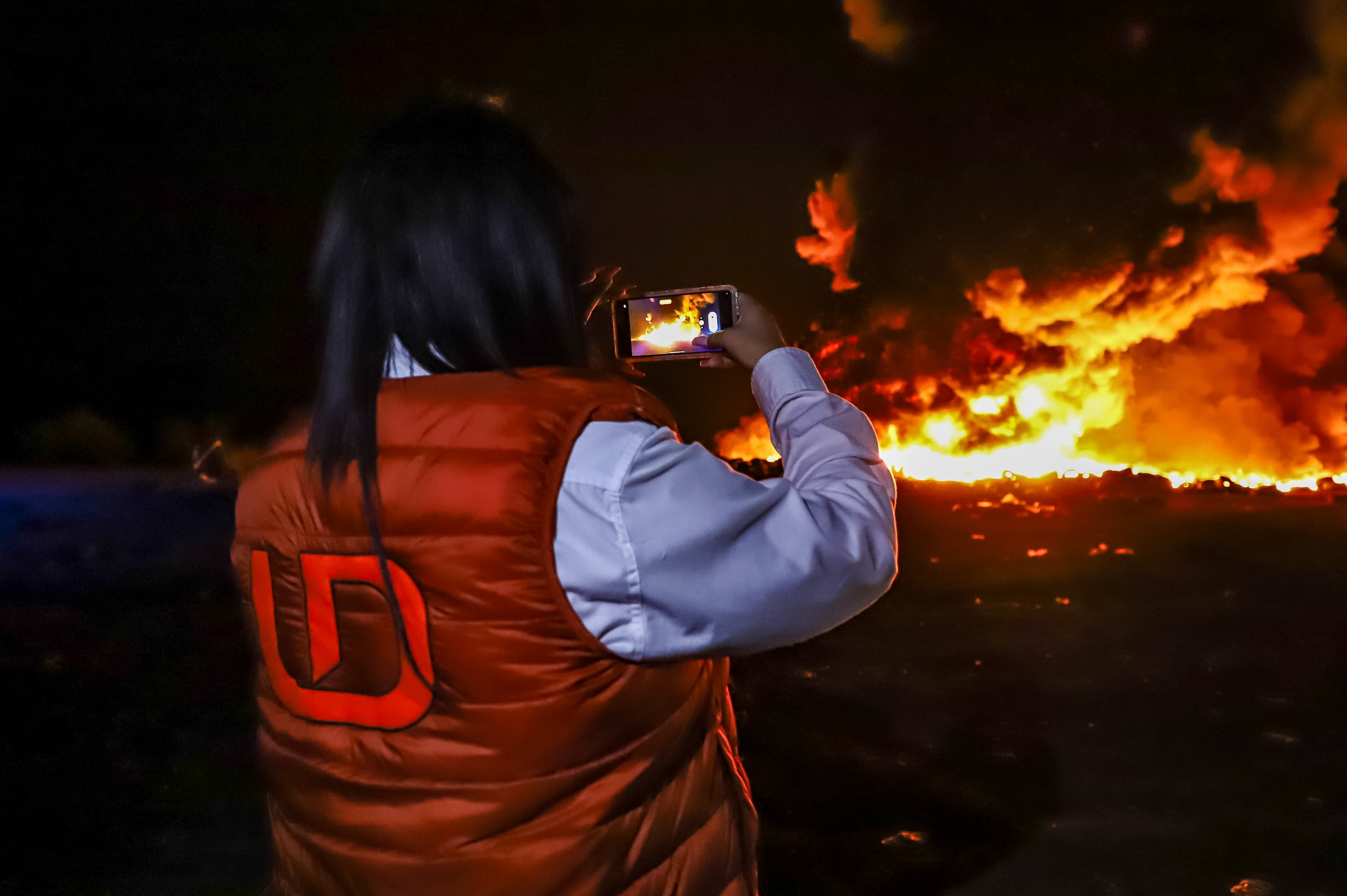 Tere Navia, reportera policiaca de Línea Directa, cubriendo la quema del basurón de Culiacán la madrugada del 7 de marzo