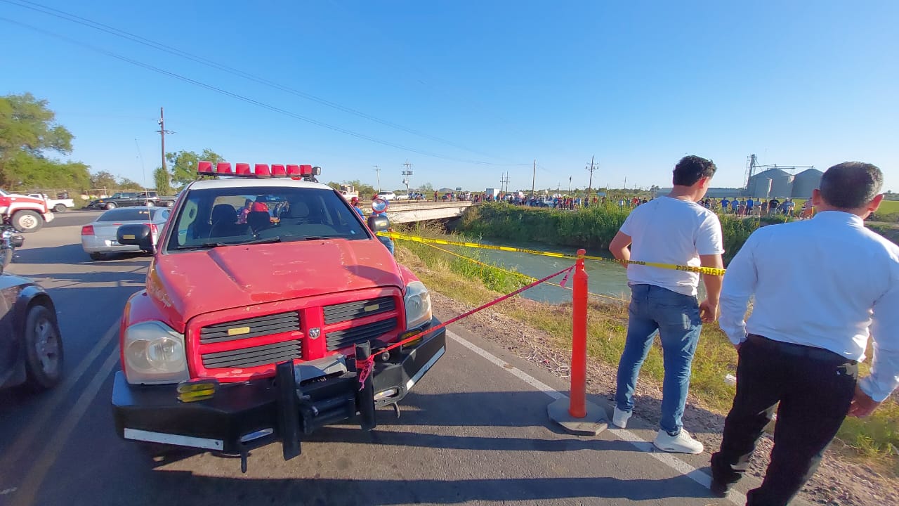 Personas en el lugar del accidente en un canal en El Fuerte