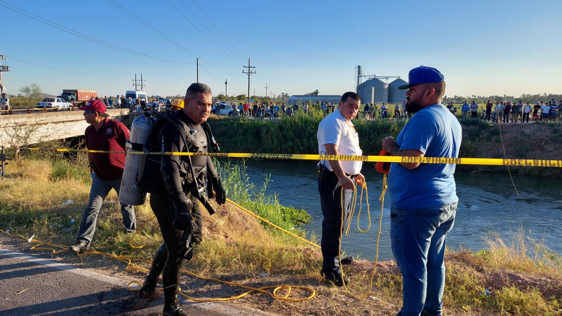 Personas en el lugar del accidente en un canal en El Fuerte
