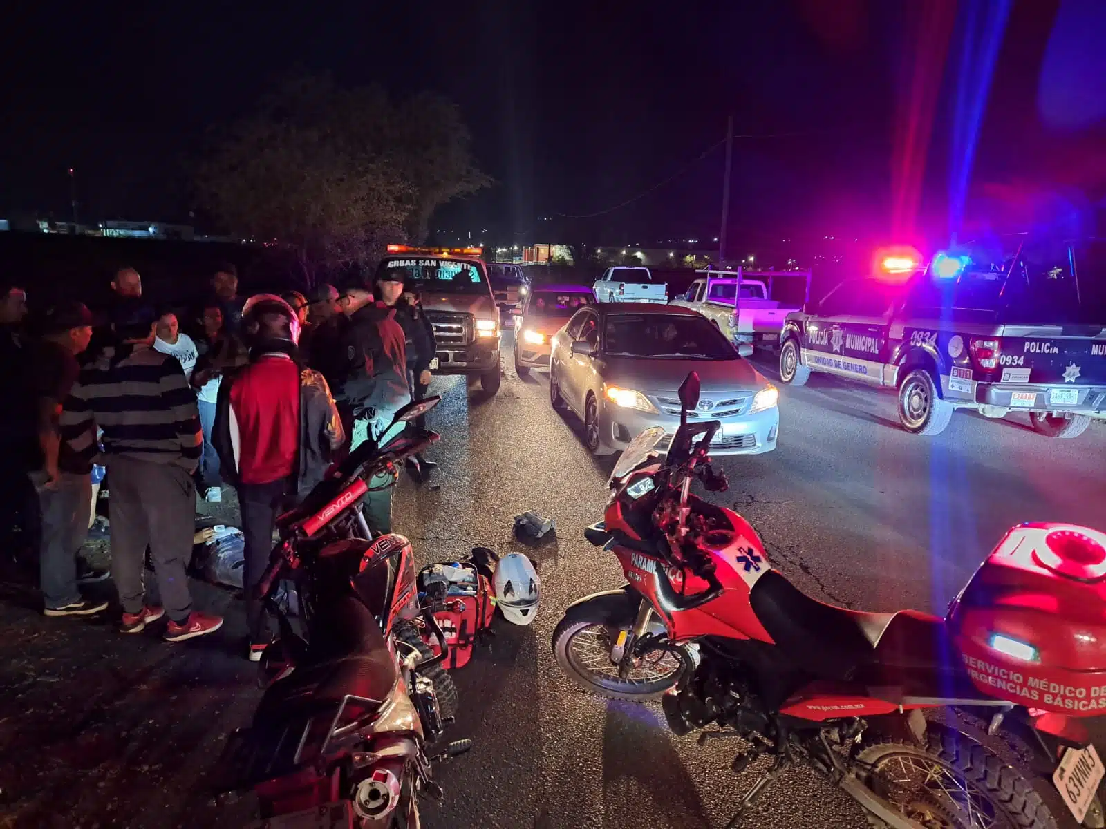 Patrulla de la Policía Municipal, carros, motocicletas y personas en el lugar donde Jesús tuvo un accidente tipo choque en Culiacán