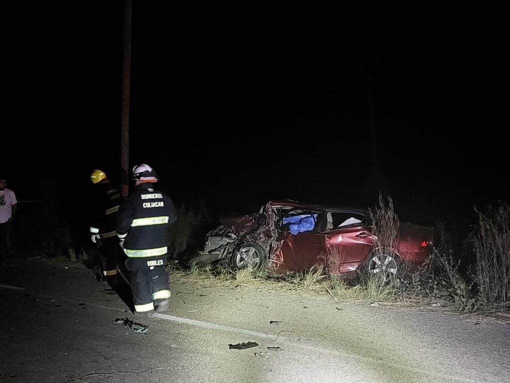 Bomberos en el lugar del accidente en Quilá, Culiacán, y al fondo el carro donde viajaban Jesús y Guadalupe