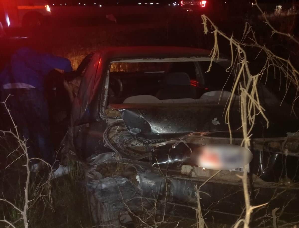 Automóvil color obscuro destrozado de la parte de atrás en medio de la noche
