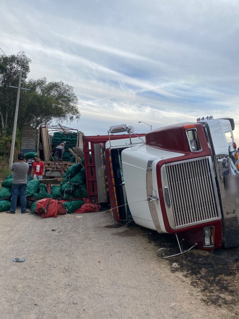 Tráiler tipo torton cargado de chiles volcado sobre el lado del copiloto en Villa Unión