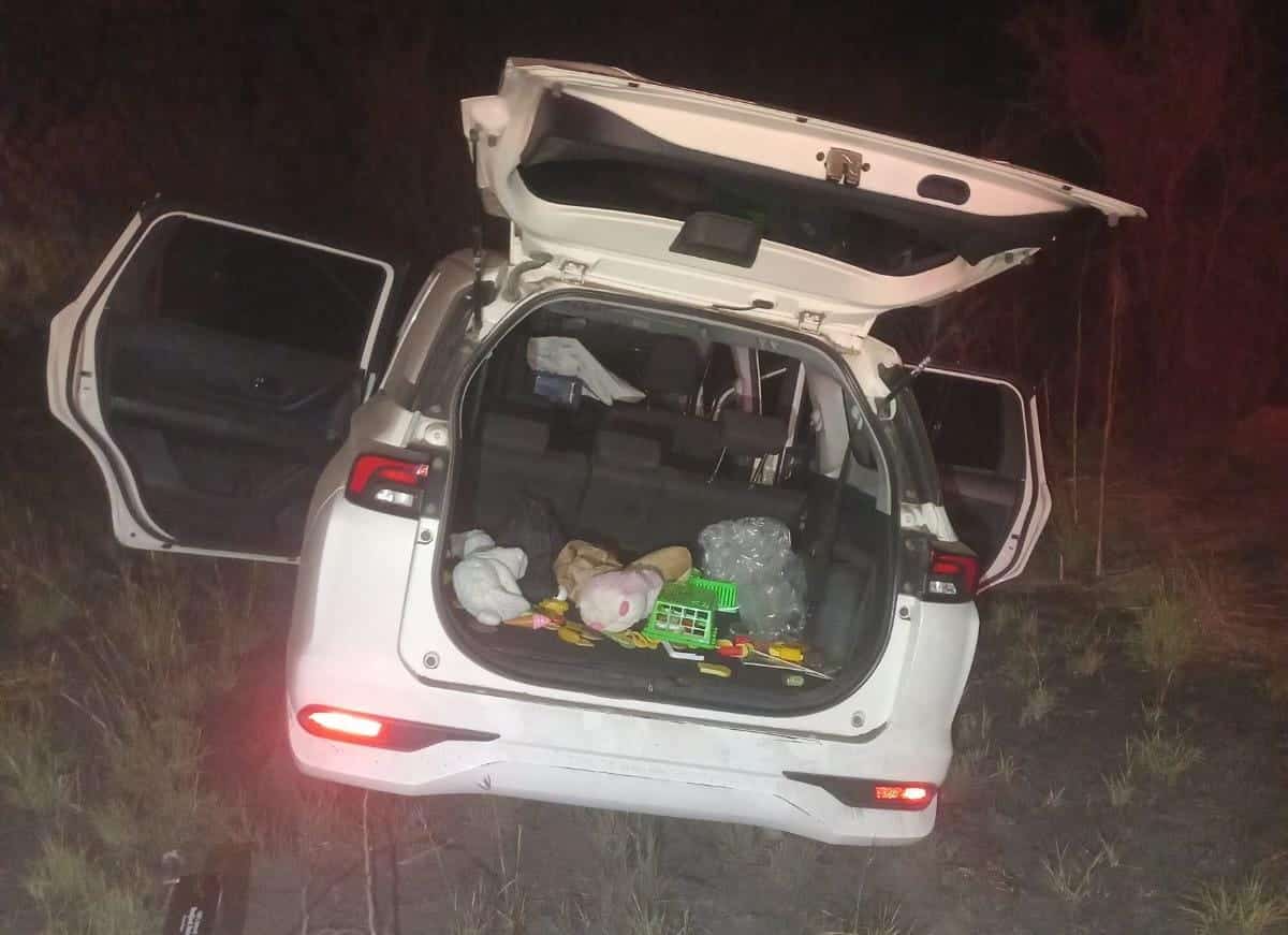Camioneta blanca con la cajuela y puertas abiertas embancada tras un choque