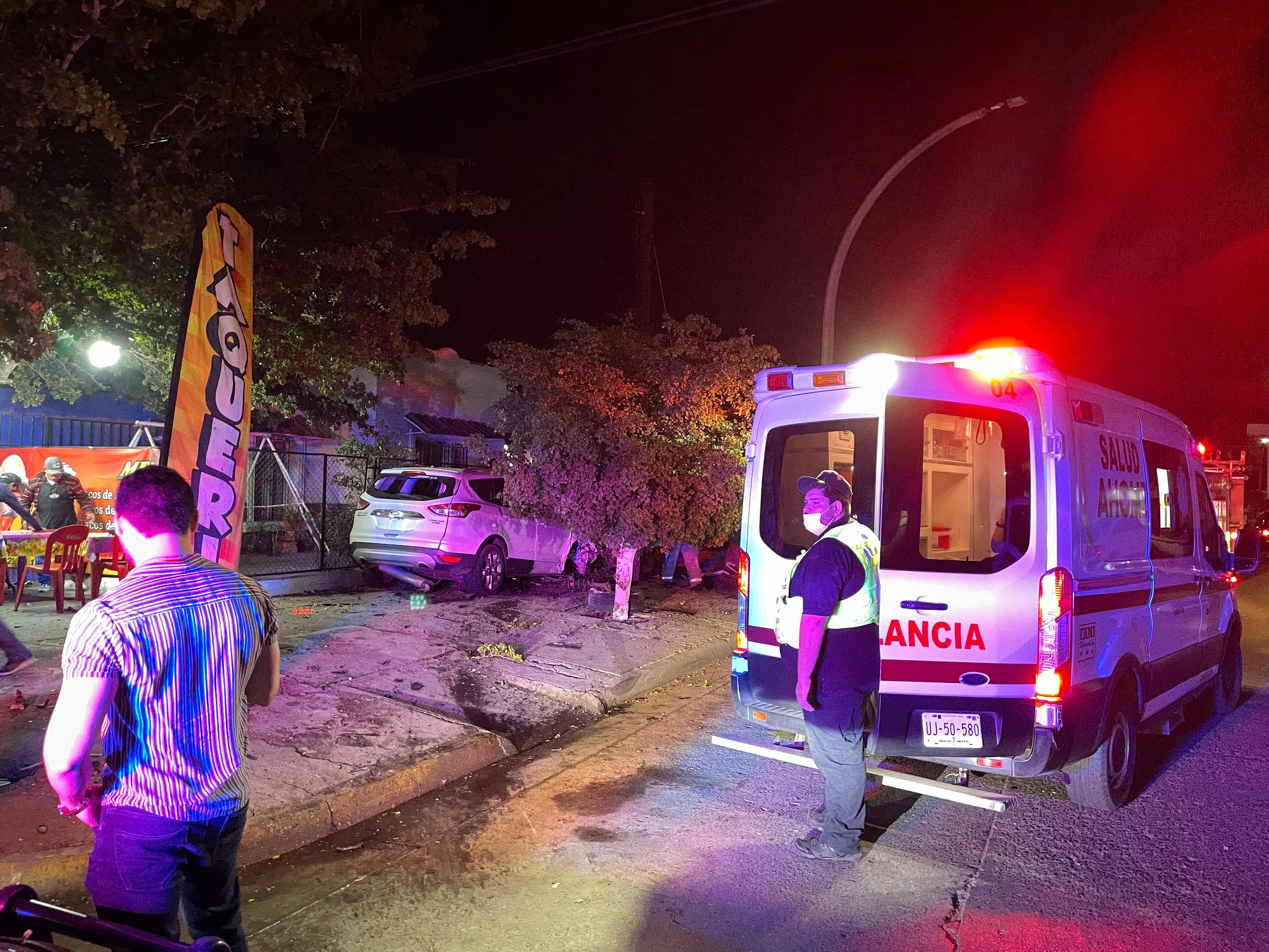 Ambulancia y paramédico de Summa afuera de puesto de tacos donde chocaron dos camionetas en Los Mochis