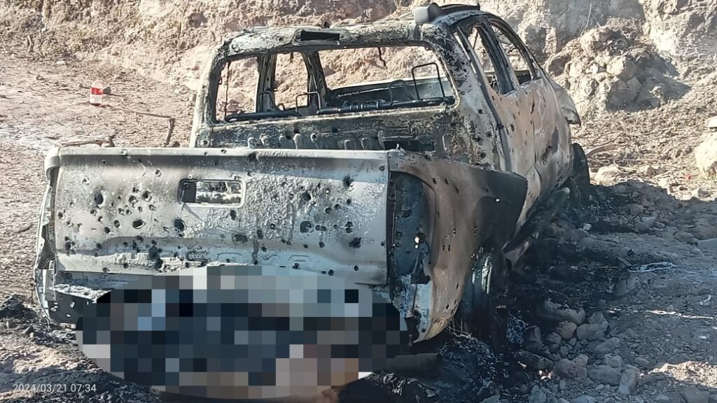 Camioneta quemada a orilla de una carretera y un cuerpo sin vida pegada a la parte trasera de la unidad