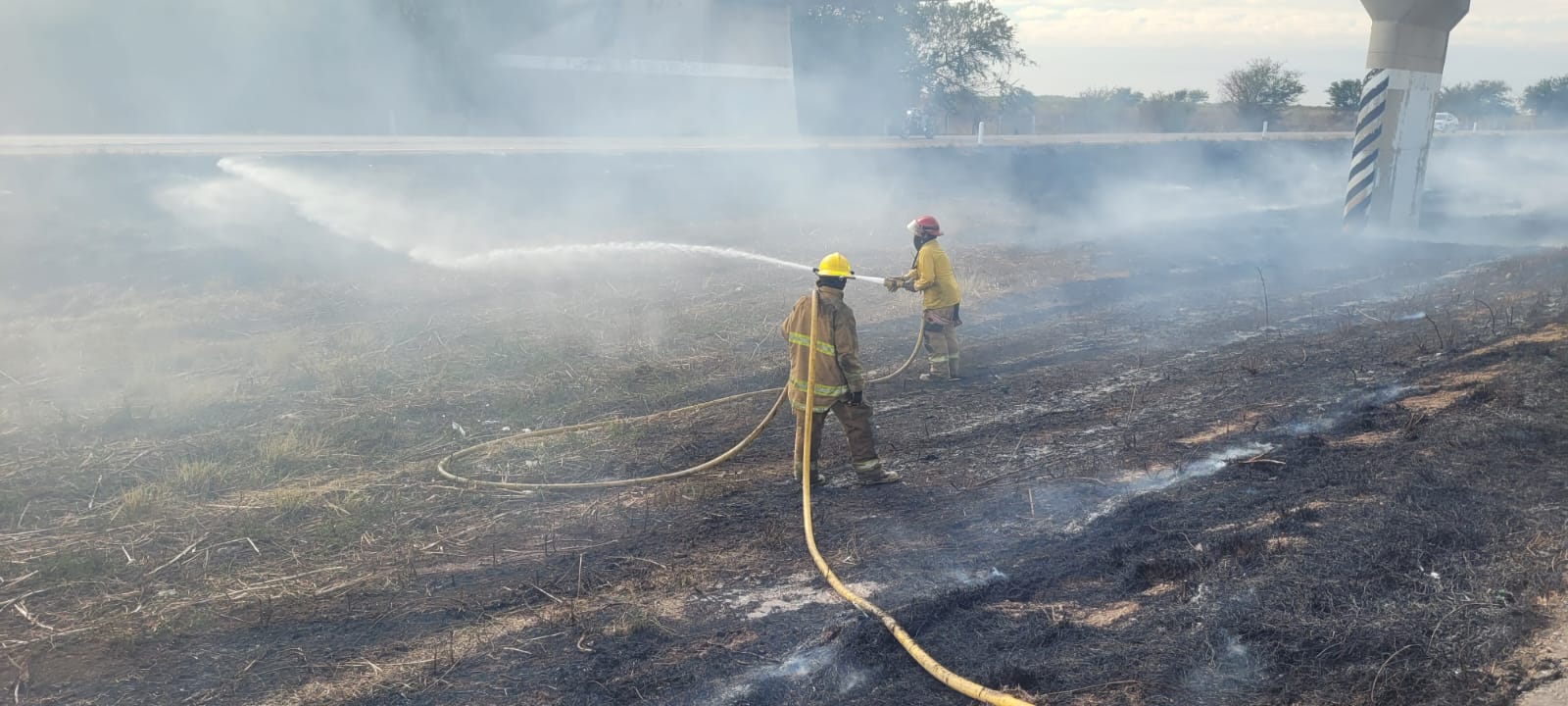 Elementos de Bomberos Voluntarios de Elota apagando un incendio por la autopista Mazatlán-Culiacán