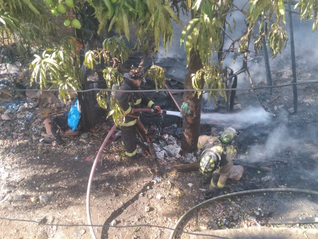 Bomberos apagan incendio en una vivienda hecha de madera y lámina