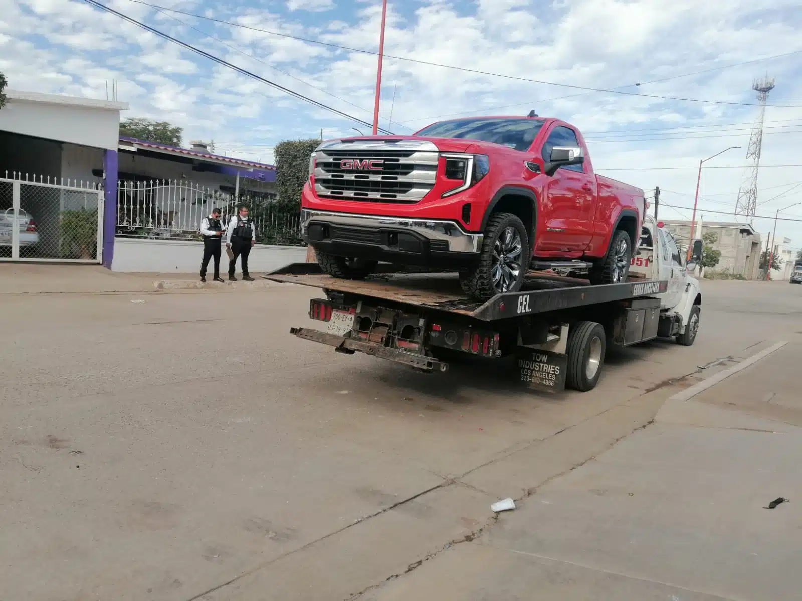 Camioneta roja arriba de una grua