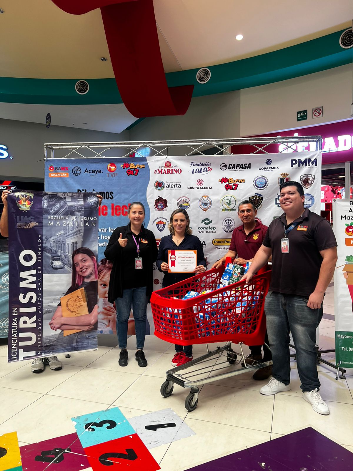 Personas en la campaña “Dibujando sonrisas con bigotes de leche” en Plaza Acaya en Mazatlán