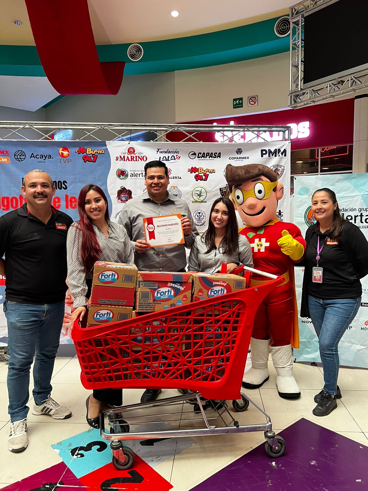 Personas en la campaña “Dibujando sonrisas con bigotes de leche” en Plaza Acaya en Mazatlán
