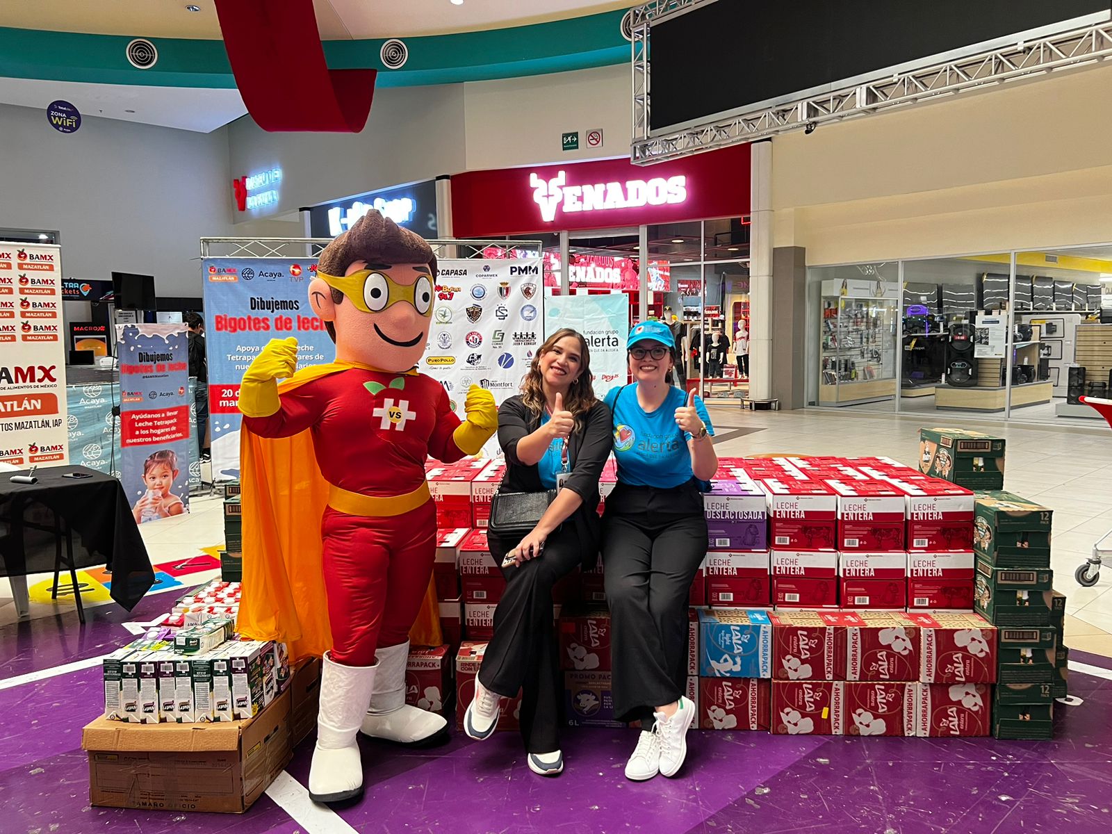 Personas en la campaña “Dibujando sonrisas con bigotes de leche” en Plaza Acaya en Mazatlán