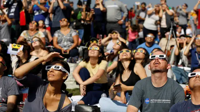 Personas viendo un eclipse con lentes especiales