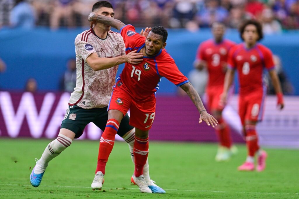 El zaguero mexicano, Johan Vásquez pelea el balón ante un futbolista panameño