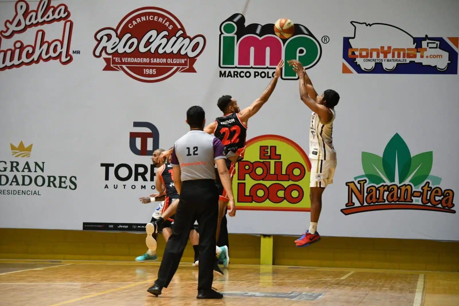 Dos jugadores de basquetbol, uno de Frayles de Guasave y otro de Zonkeys de Tijuana, disputándose un balón en el Gimnasio Luis Estrada Medina