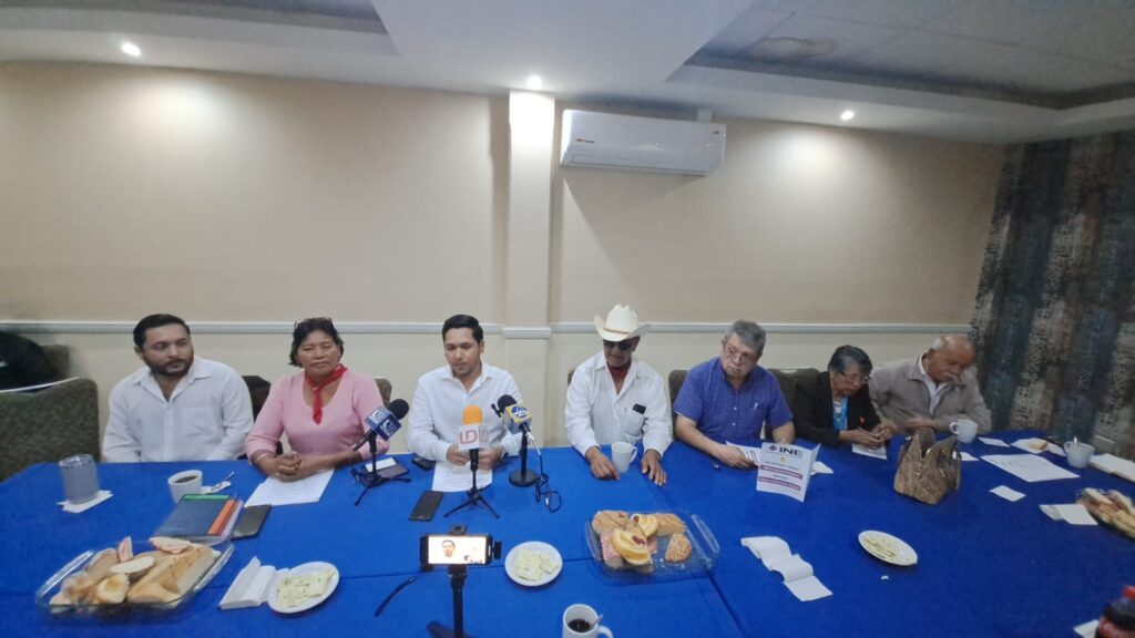 José Francisco Villegas Elizalde con una hoja del INE en sus manos junto a más personas más en una conferencia de prensa en Ahome