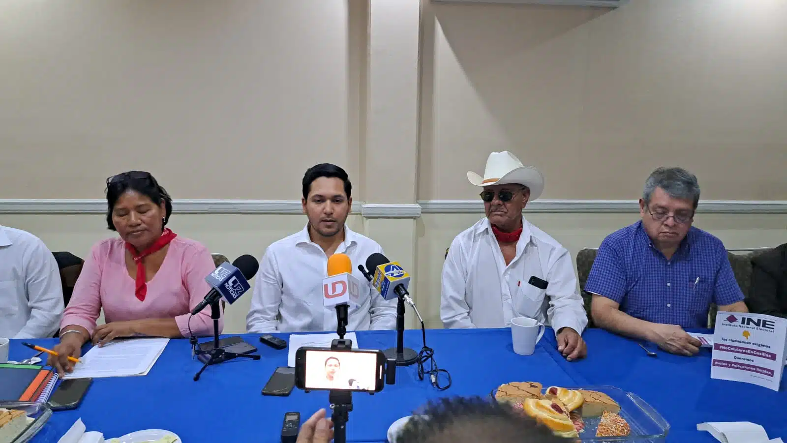 José Francisco Villegas Elizalde con una hoja del INE en sus manos junto a 3 personas más en una conferencia de prensa en Ahome