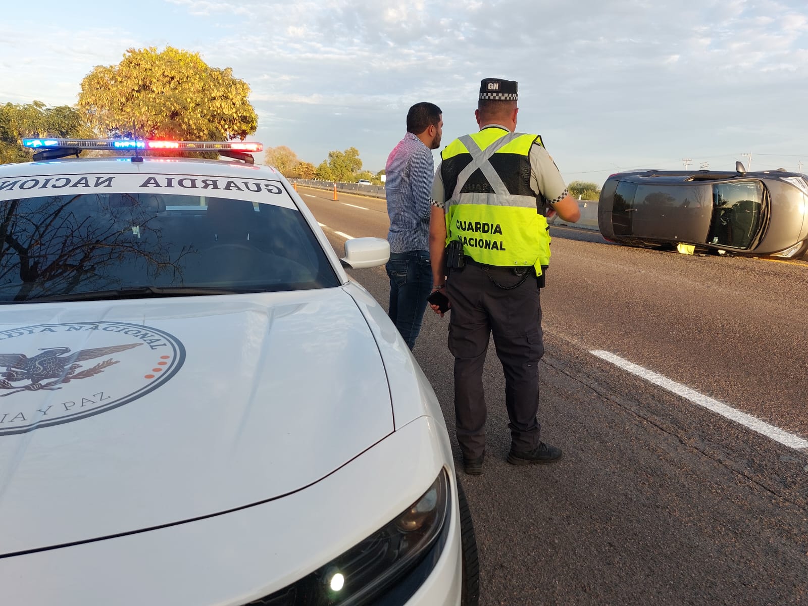 Patrulla y elemento de la Guardia Nacional en el lugar donde un carro se volcó sobre el lado de copiloto en Navolato