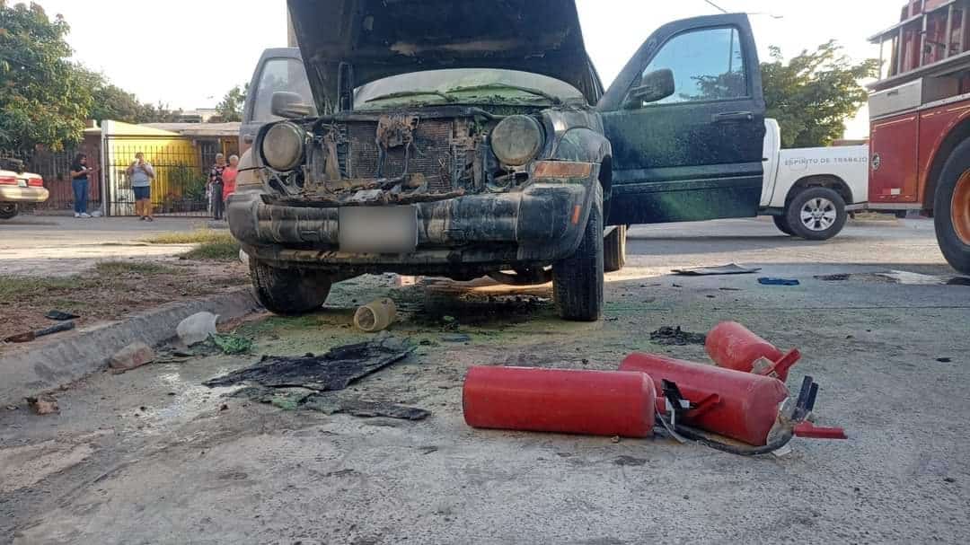 Camioneta con el cofre abierto y las puertas abiertas tras incendiarse, en el piso extintores con los que controlaron las llamas en Los Mochis