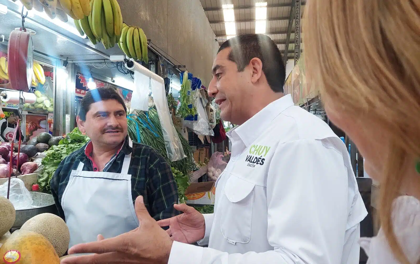 Jesús Valdés hablando con vendedor en mercado