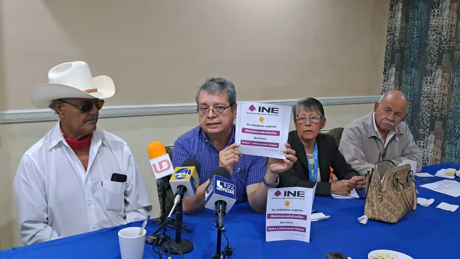 José Francisco Villegas Elizalde con una hoja del INE en sus manos junto a 3 personas más en una conferencia de prensa en Ahome