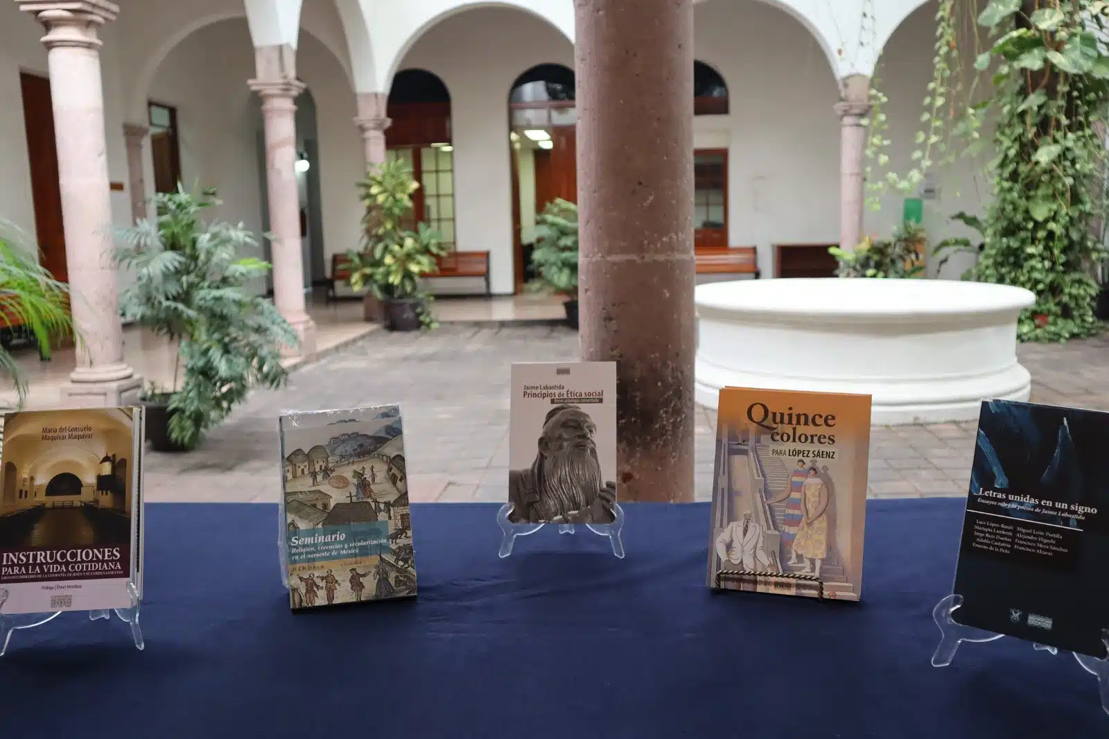 Libros parados sobre una mesa con un mantel azul en el Colegio Sinaloa en Culiacán