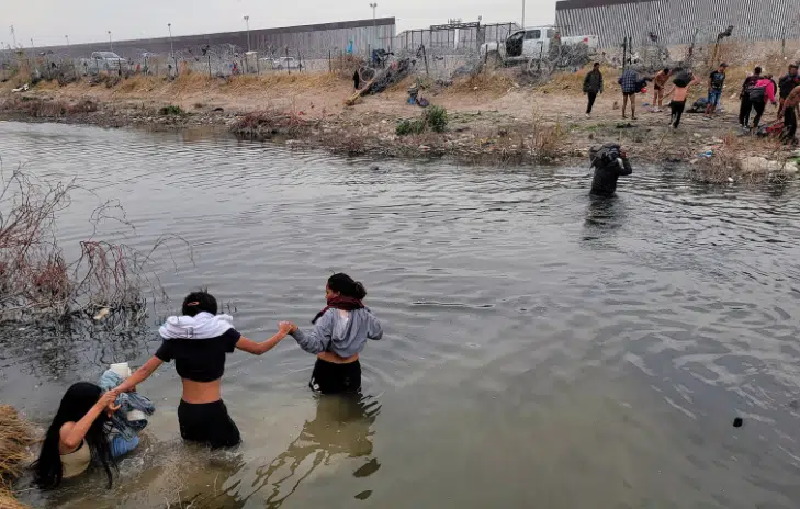 Migrantes cruzando el Rio