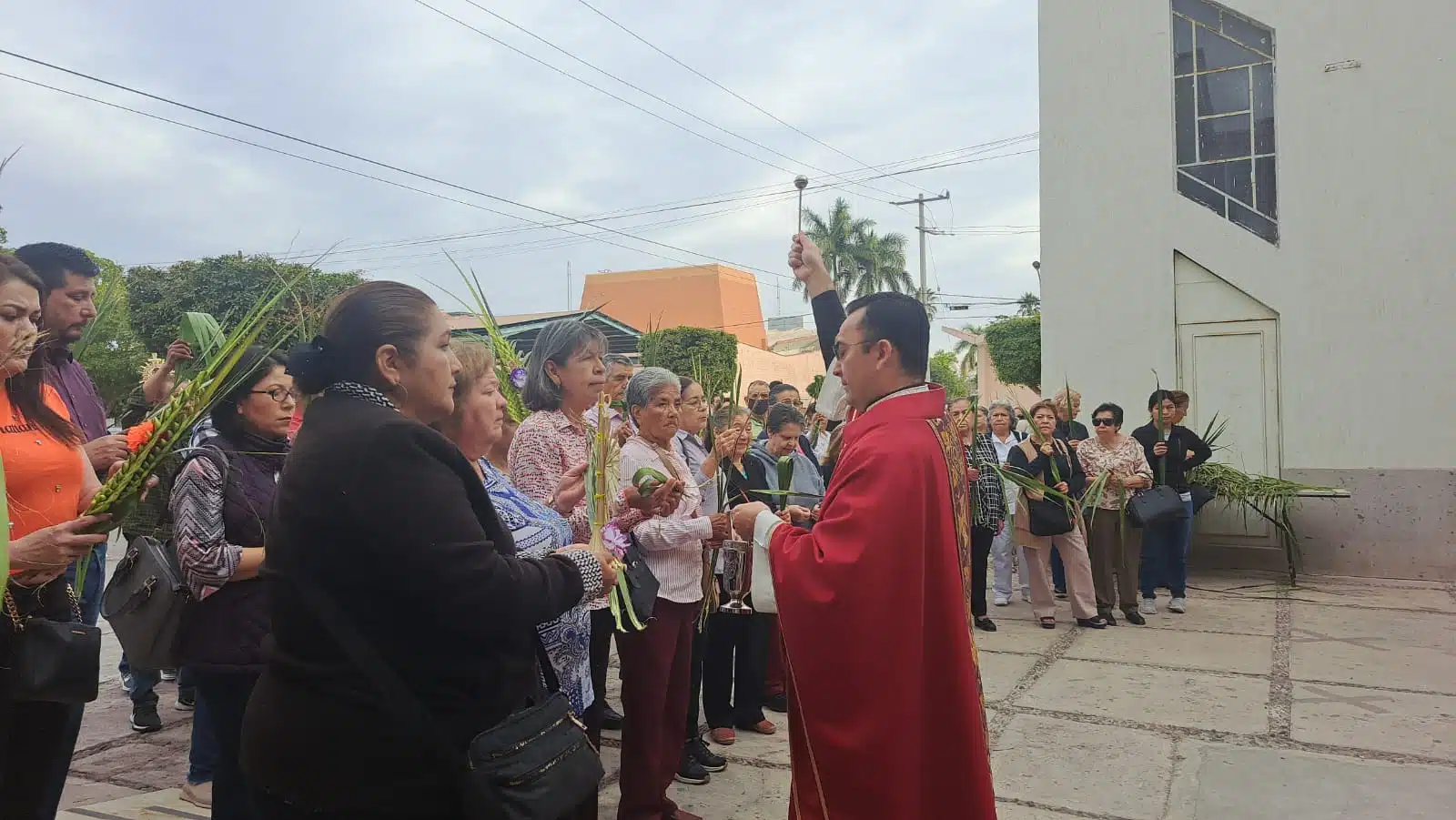 Párroco de la iglesia San José en Los Mochis bendiciendo las palmbas de feligreses en el Domingo de Ramos