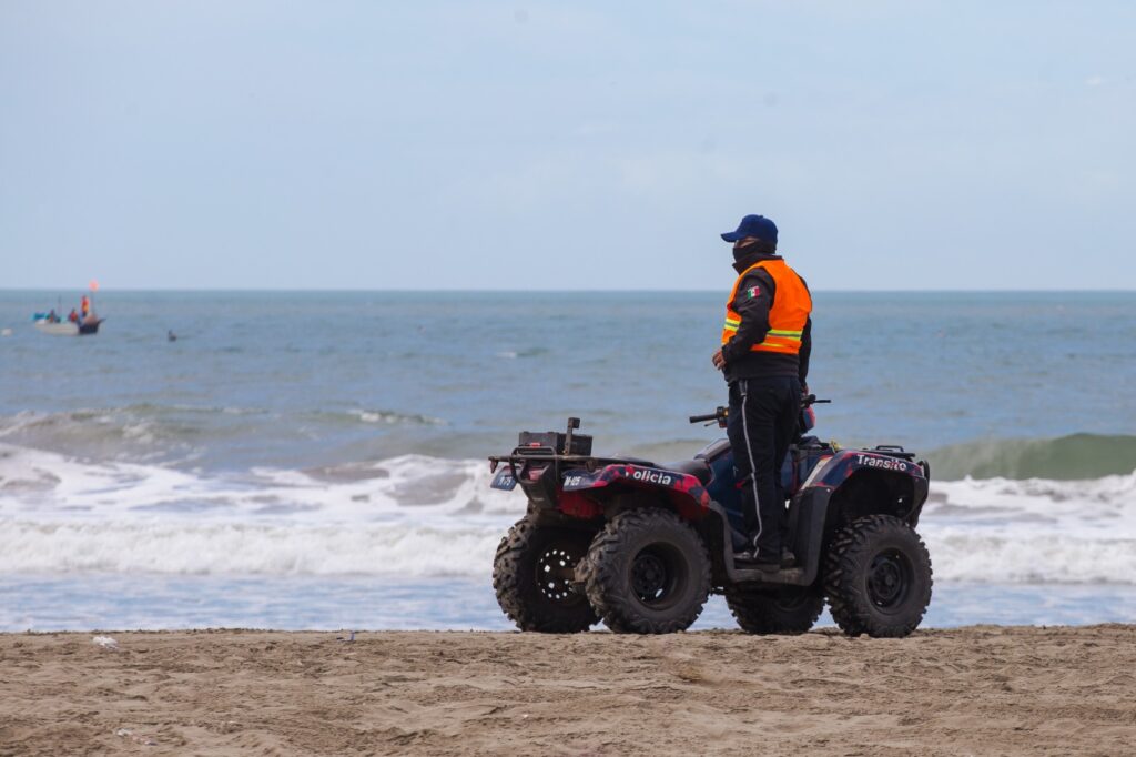 Elemento de la Policía Municipal de Guasave arriba de una cuatrimoto a la orilla de la playa en Las Glorias, Guasave