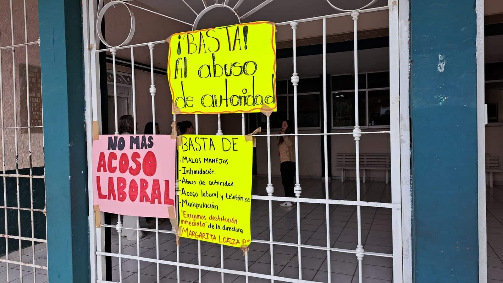 Cartulinas con mensajes en la puerta principal de una escuela