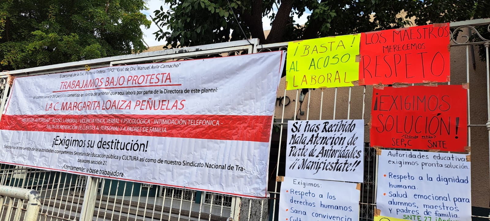 Cartulinas con mensajes en la puerta principal de una escuela