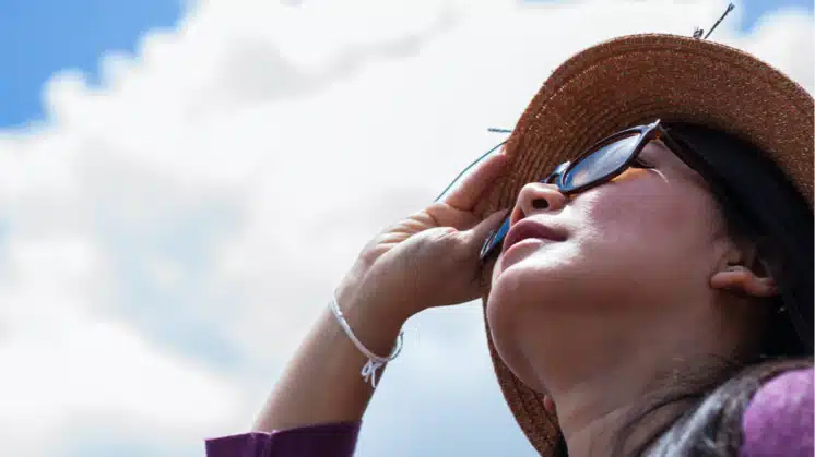 Mujer con sombrero protegiéndose del sol