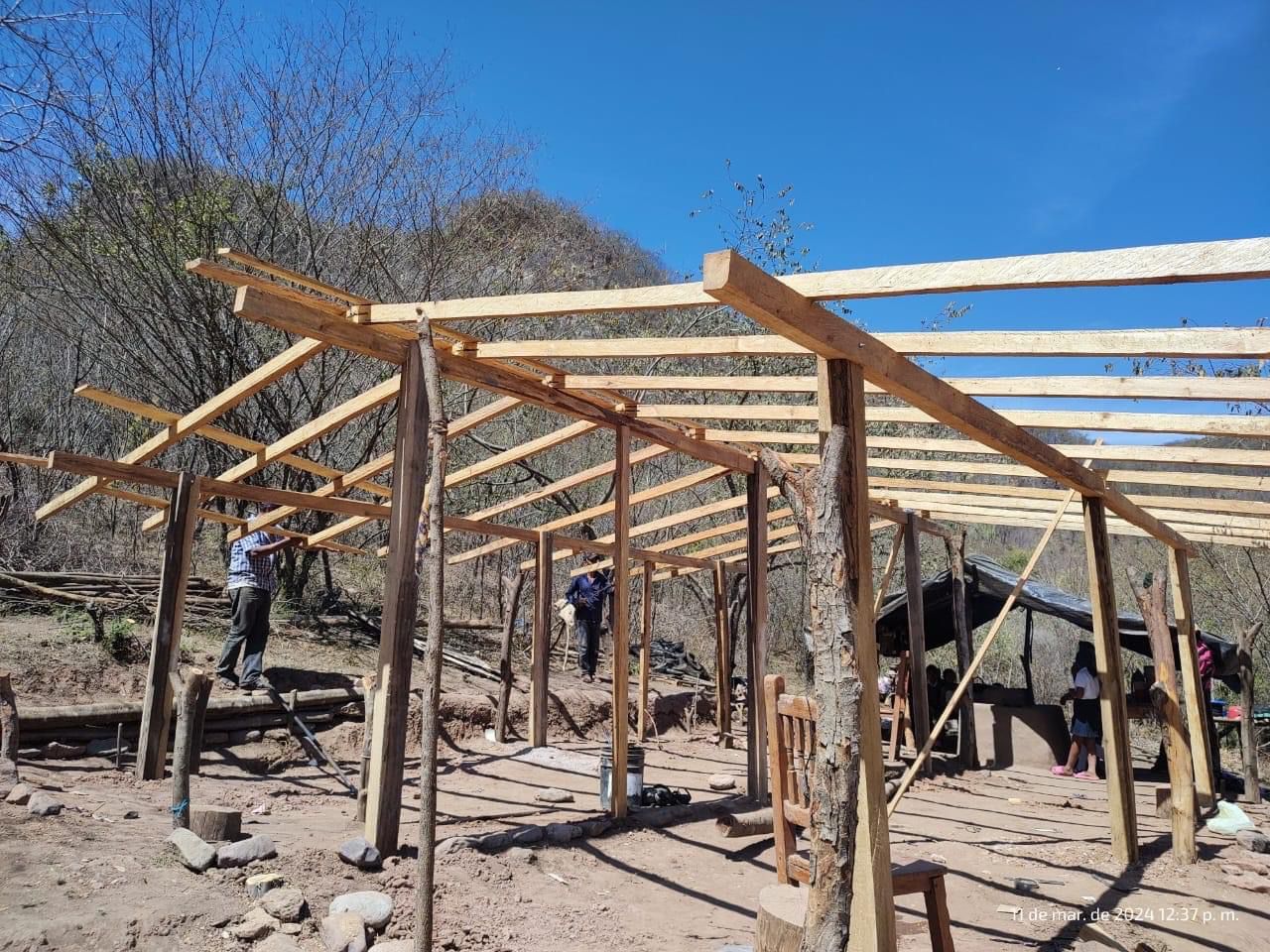 Casa de madera de una mujer indígena con sus hijos