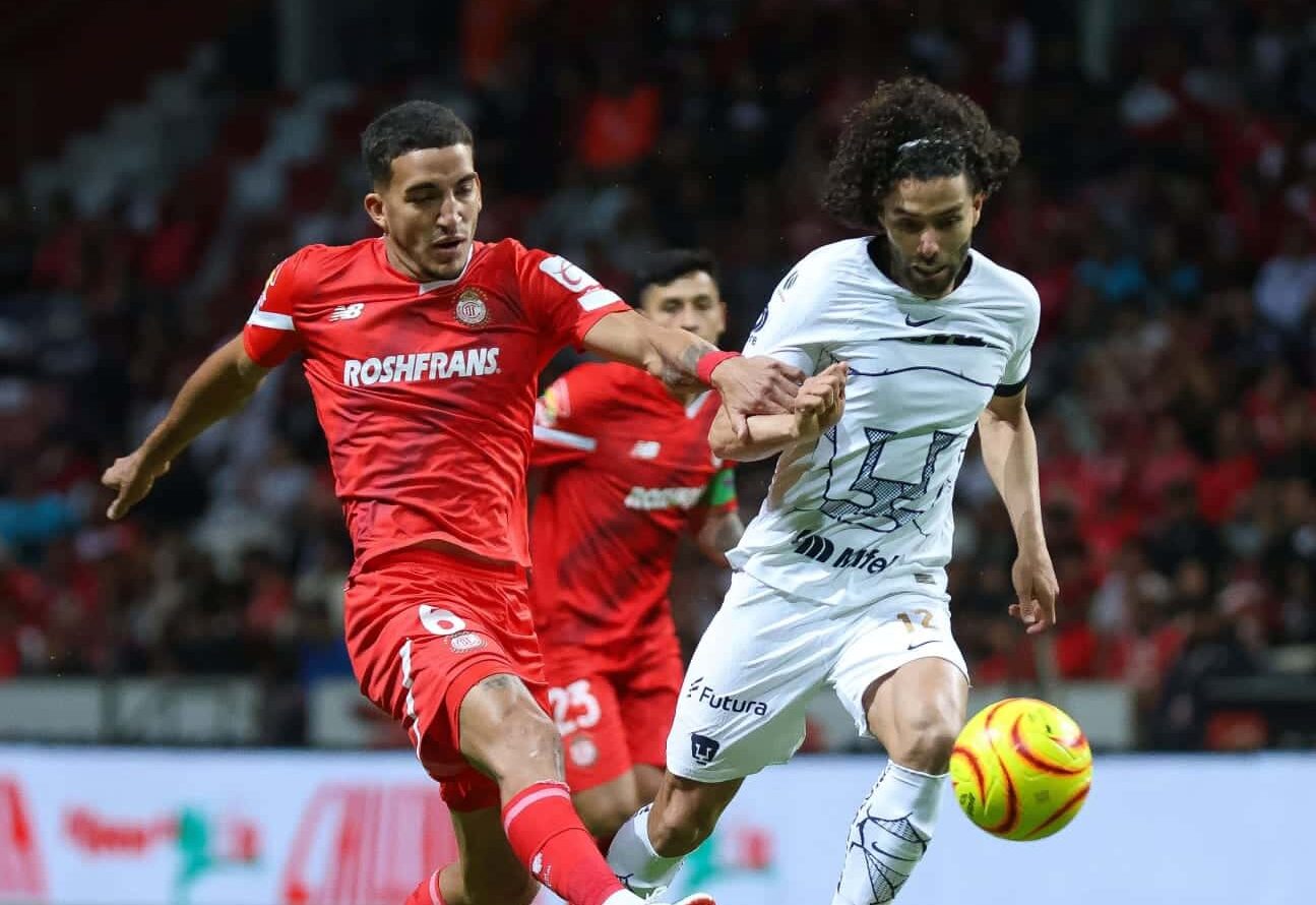 Jugadores de Toluca y Pumas disputándose un balón de futbol