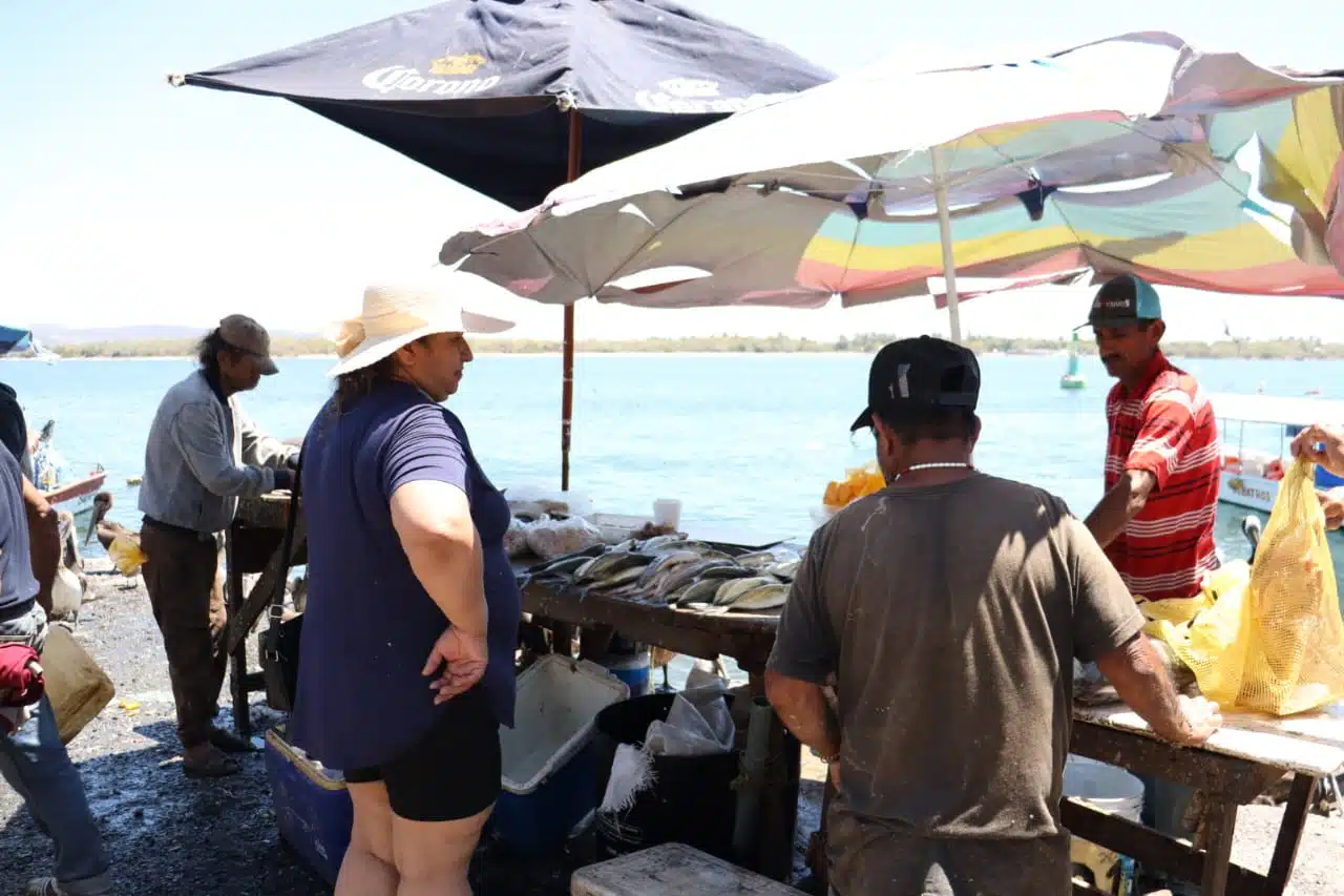Turistas comprando pescado fresco