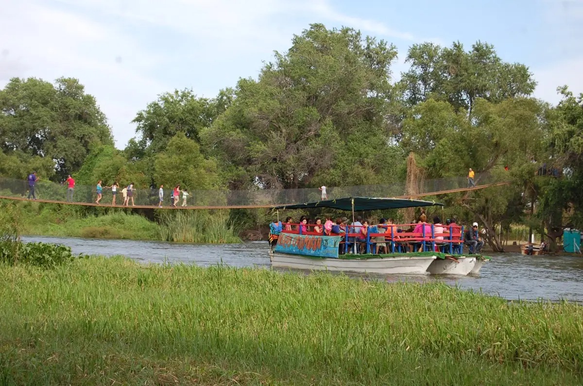 Turistas pasan por el puente del río Sinaloa en Isla del Encanto
