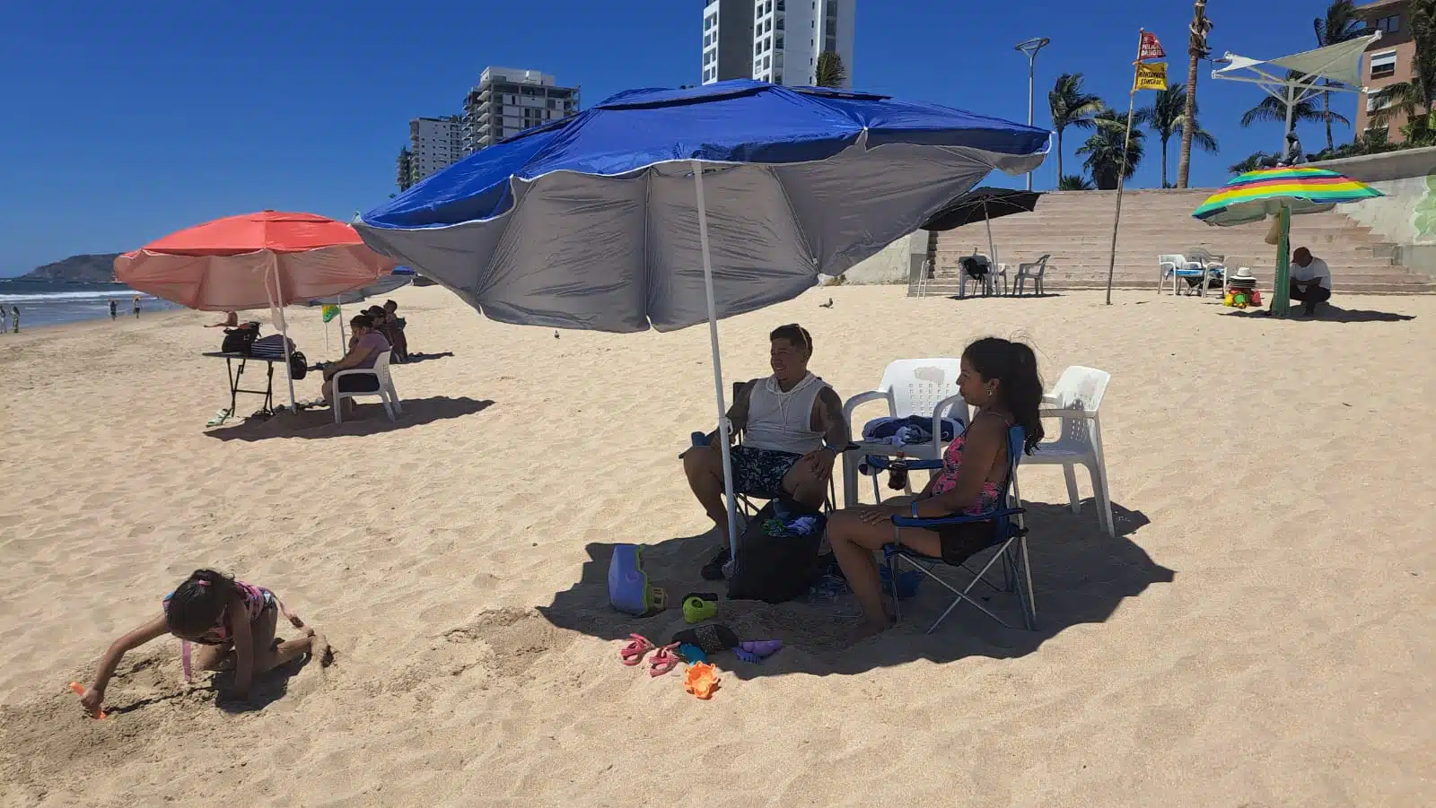 Jesús Aldape junto a su esposa y su hija, jugando, en la playa de Mazatlán