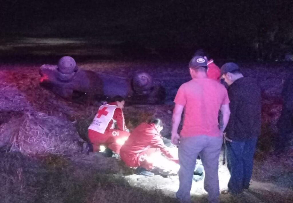 Auto volcado y paramédicos y civiles socorriendo a la conductora