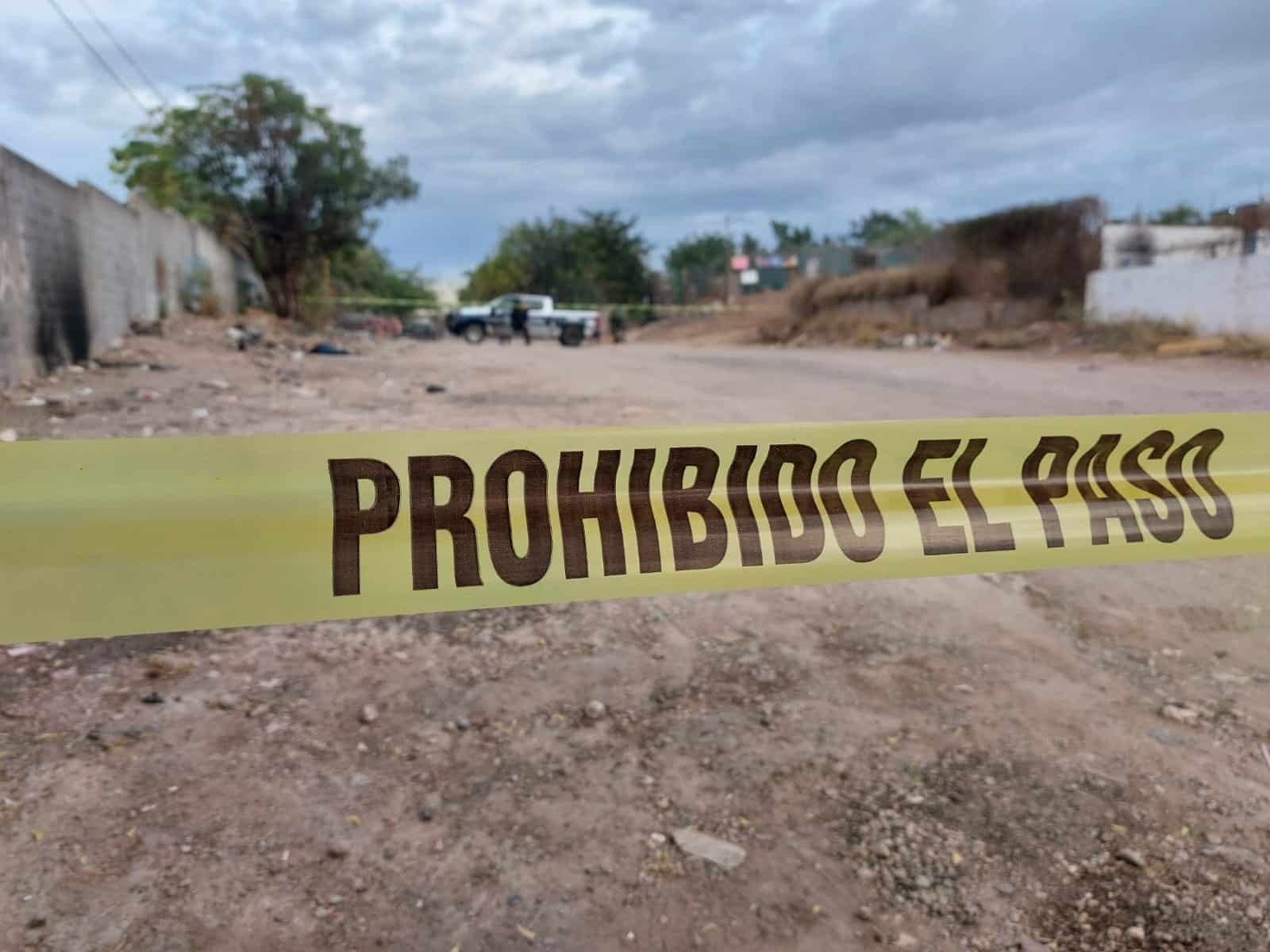 Calle de terracería acordonada con cinta amarilla y elementos del Ejército y de la Policía Municipal en la zona donde encontraron a una persona asesinada