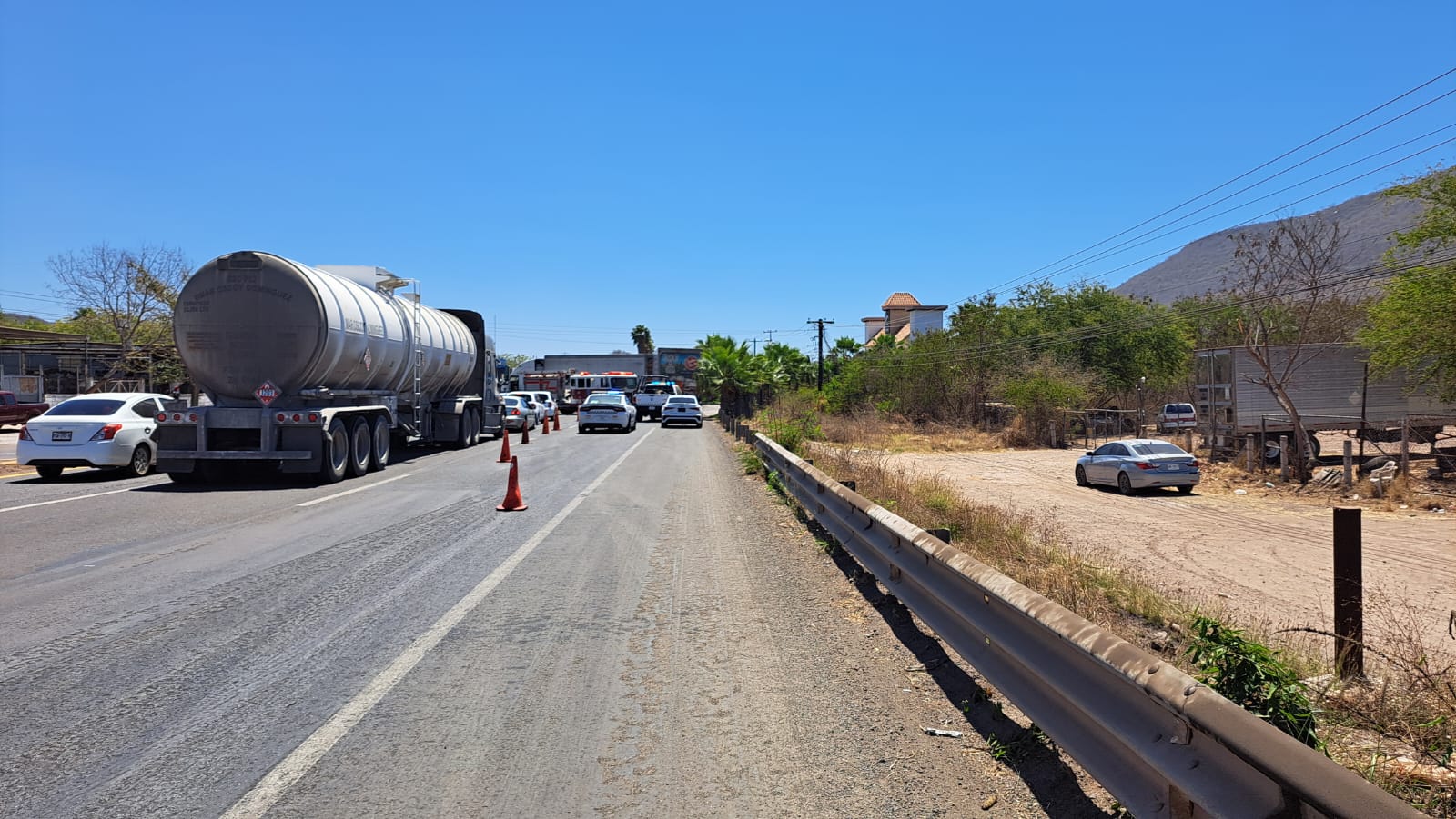 Trafico vial tras accidente de un tráiler y un un automóvil Toyota Corolla color gris