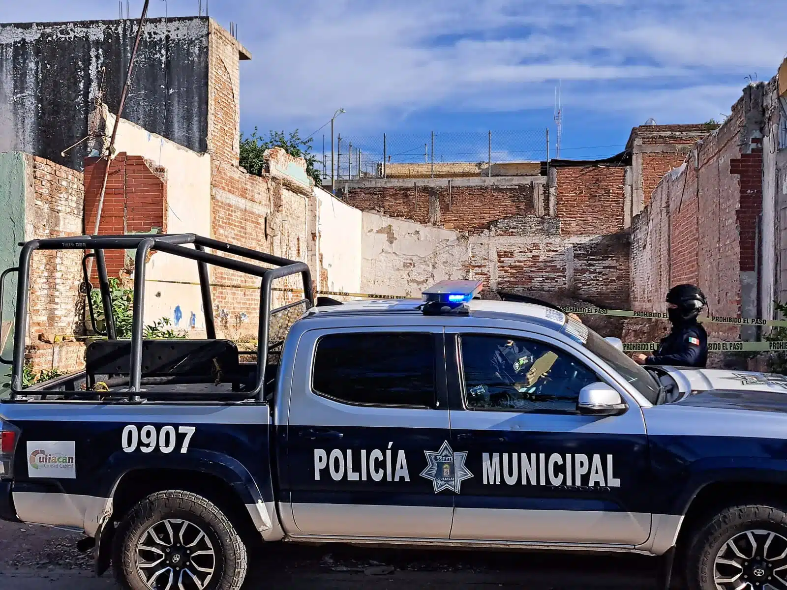 Patrulla de la Policía Municipal frente al terreno baldío donde se encontró el cuerpo sin vida de Edgardo