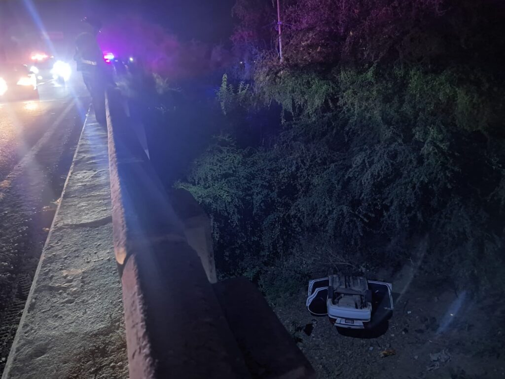 Vehículo volcado a un costado del puente tras caída