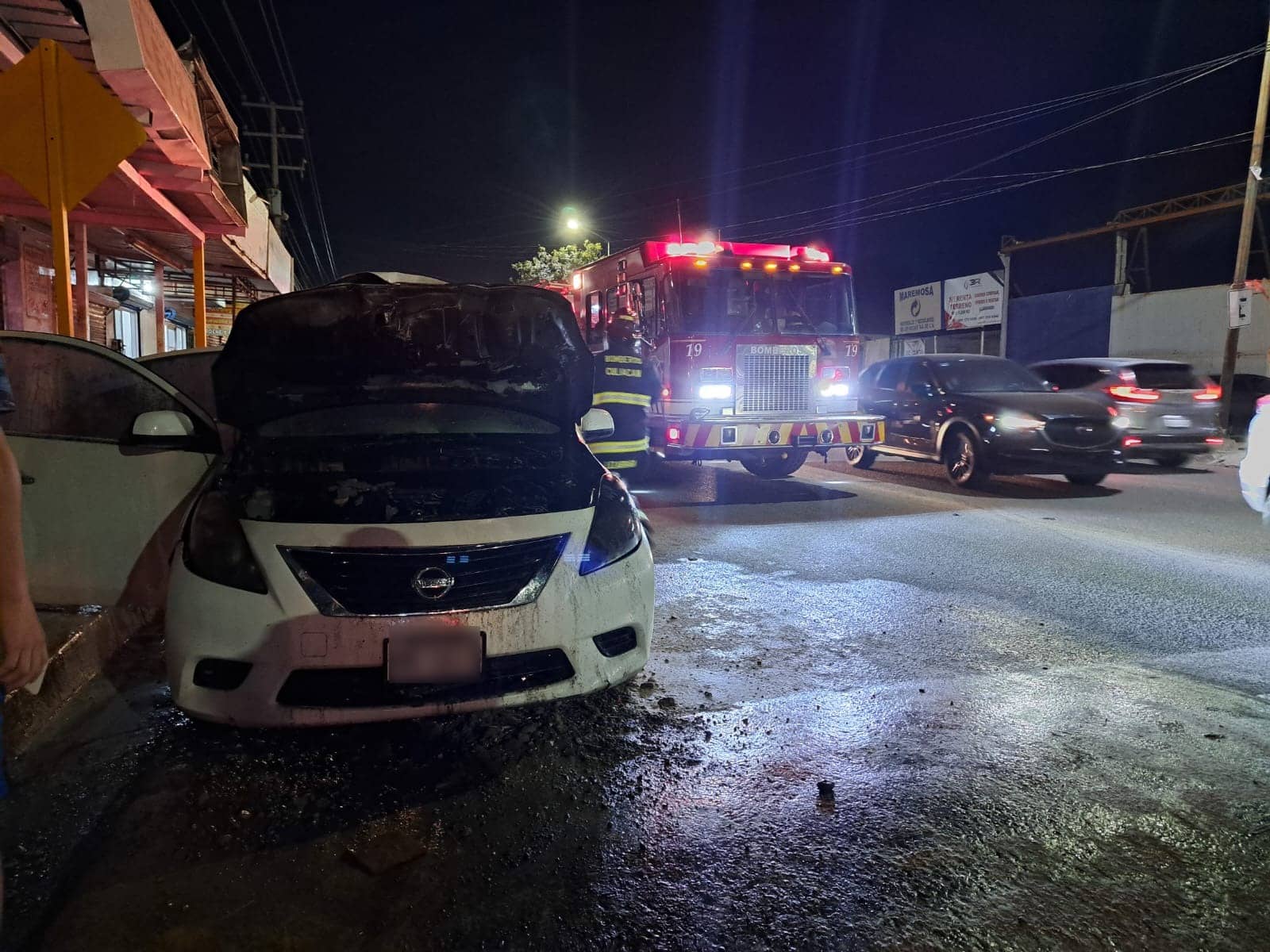 Camión de Bomberos junto al vehículo incendiado