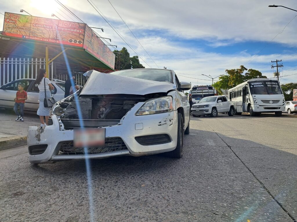 Vehículo Nissan Sentra gris con daños en la carrocería