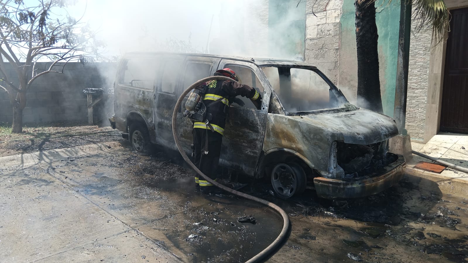 Bomberos apagando incendio de camioneta