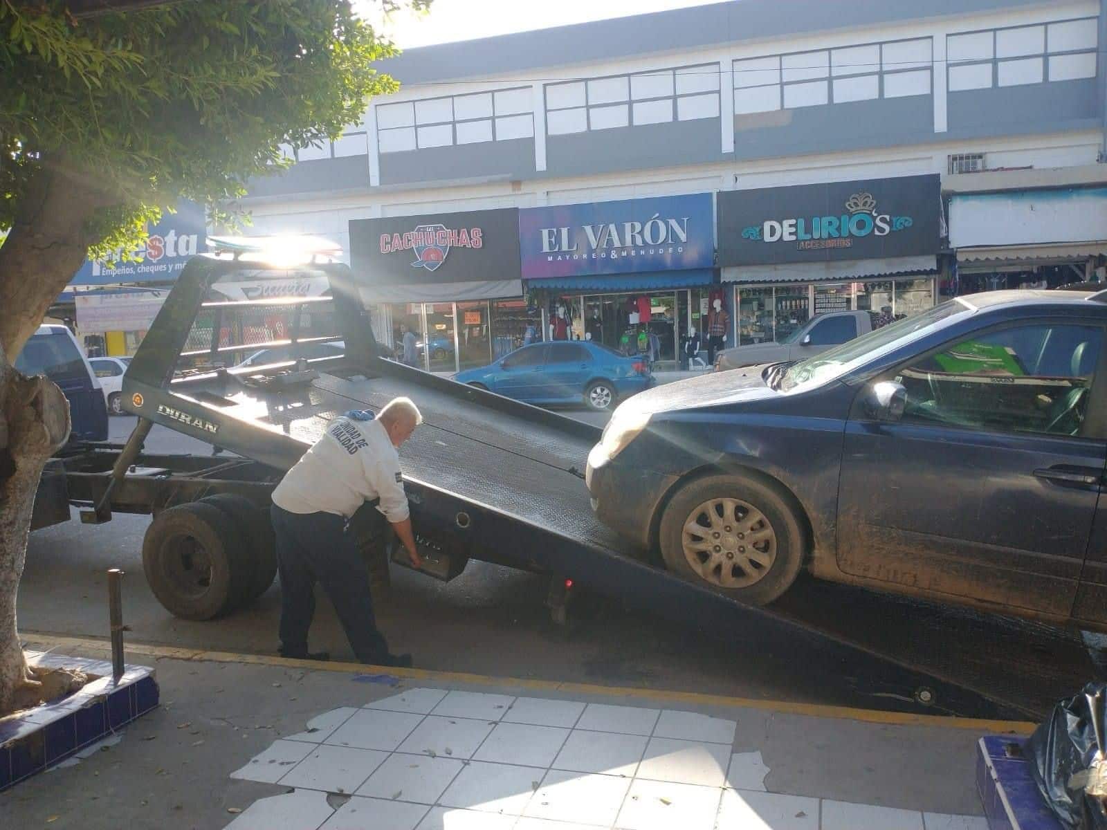 Policía de Tránsito Municipal de Ahome llevándose automóvil mal estacionado.