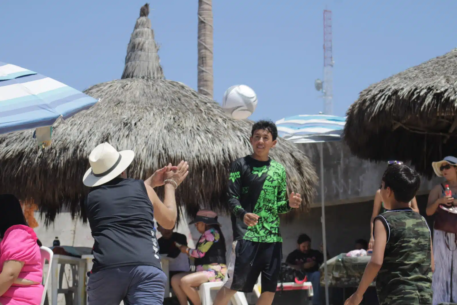 Turistas jugando voleibol en playa de Mazatlán.