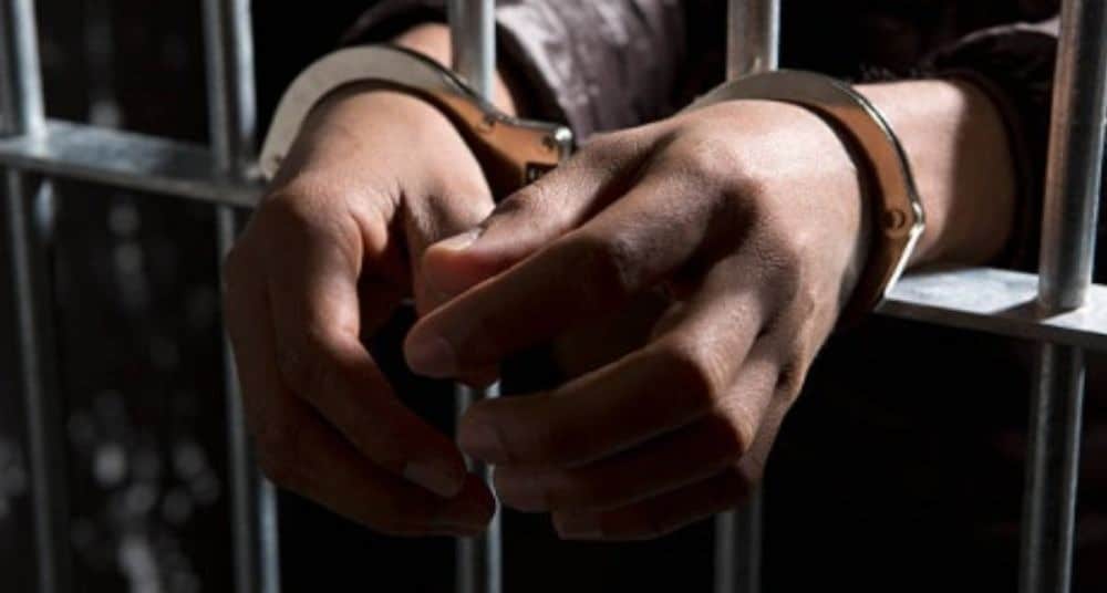 Hombre esposado en celda