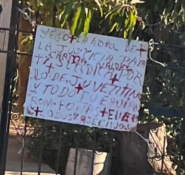 Cartel colocado en reja de casa