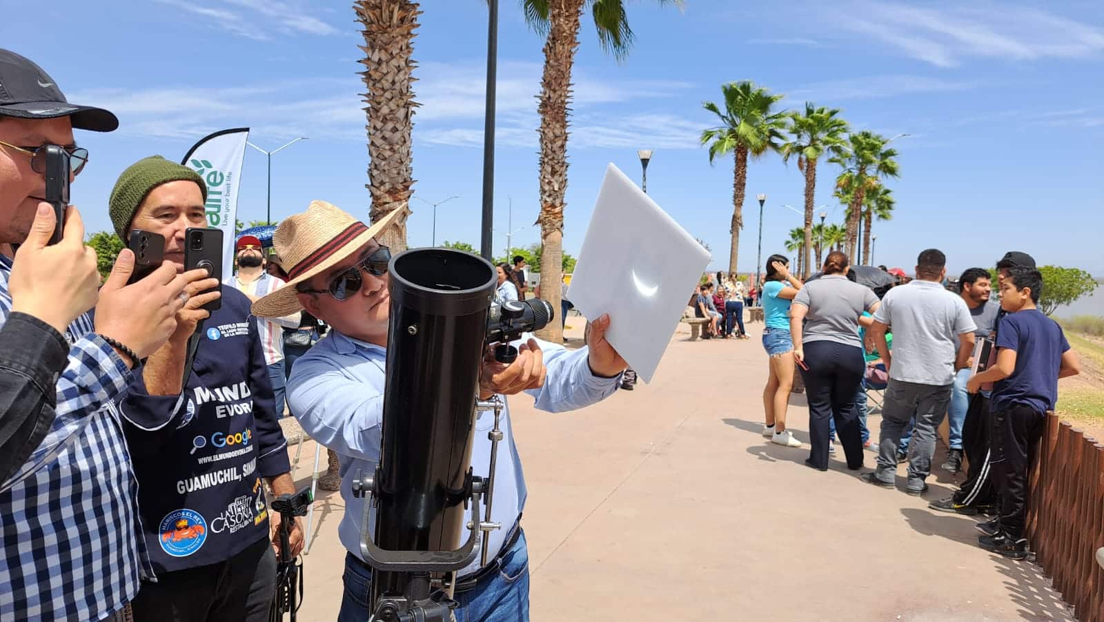Personas en la presa Eustaquio Buelna mirando el eclipse total de Sol en Guamúchil